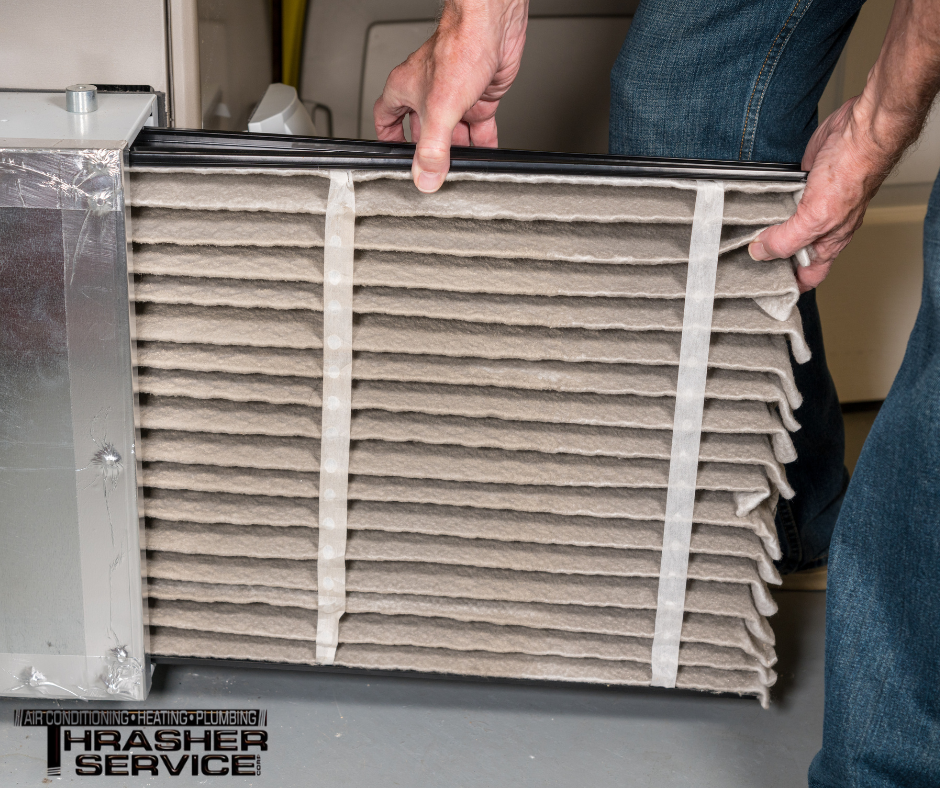 A Thrasher Services HVAC Technician replaces a furnace air filter while on a furnace tune up service call at a Des Moines metro area home. 
