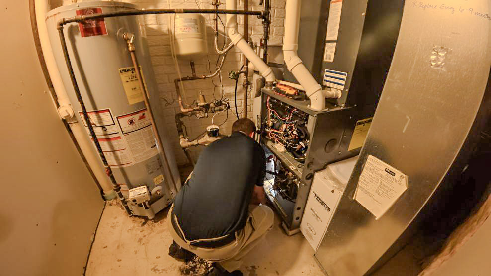 A Thrasher Service HVAC tech performs a yearly furnace tune up in Des Moines to prepare this homeowner for the winter.
