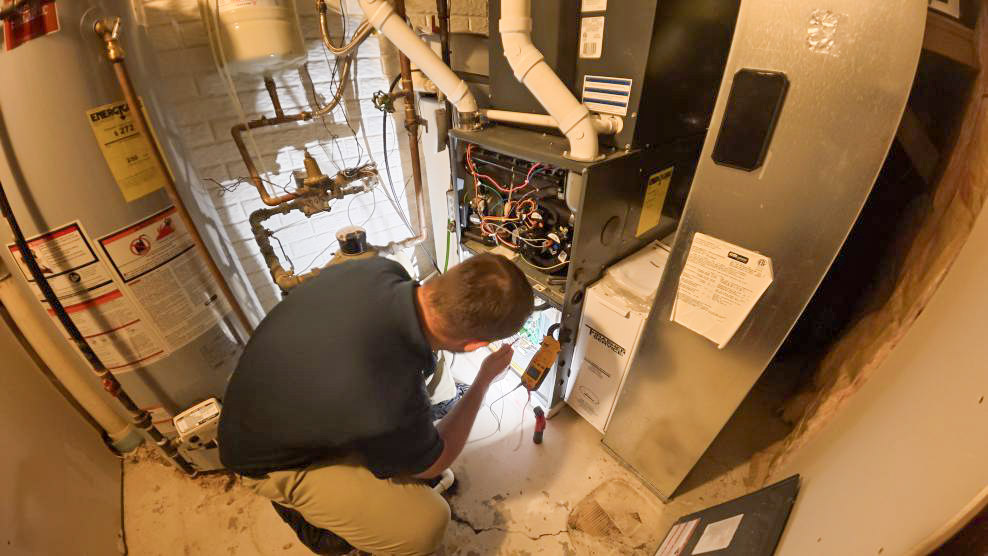 A Thrasher Service HVAC technician performs an emergency furnace repair in Des Moines after a client's heat went out.