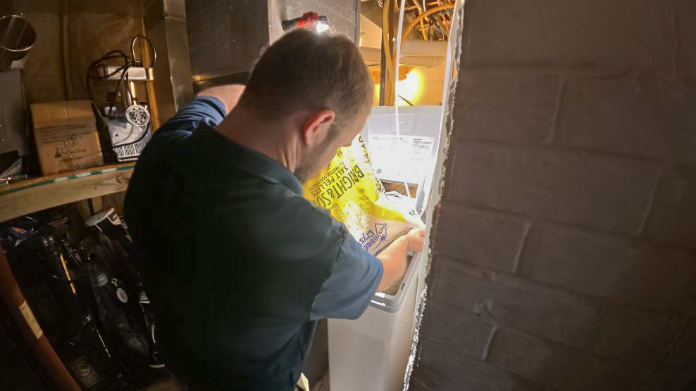 A Thrasher Service plumber finishes a water softener installation in Des Moines.
