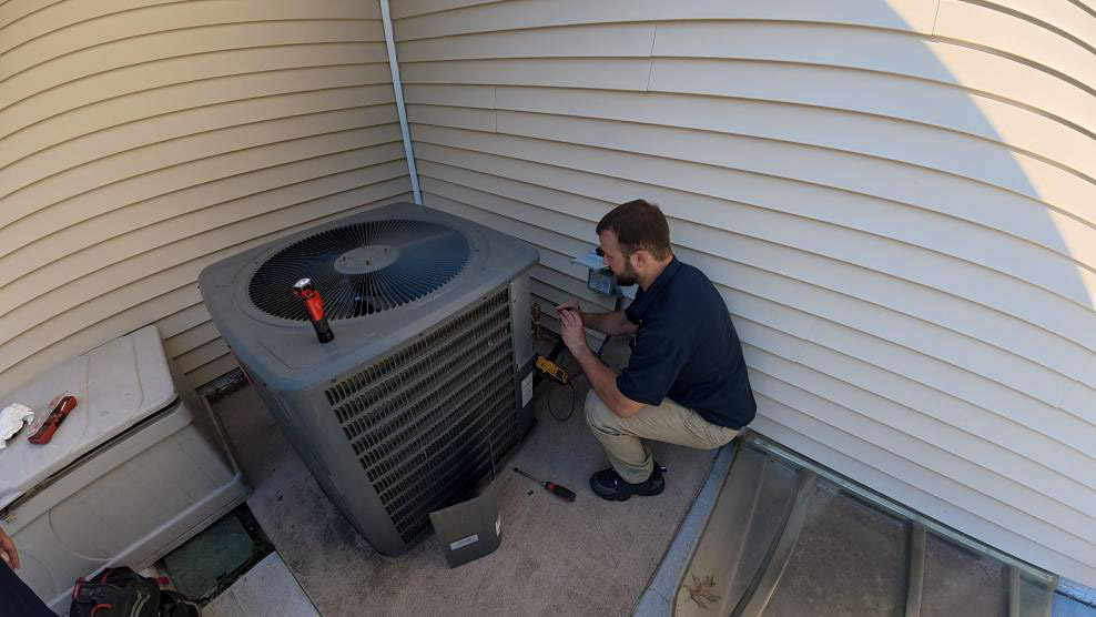 A Thrasher Service HVAC technician performs an air conditioner repair in the Des Moines area.