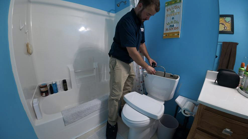 A Des Moines plumber from Thrasher Service fixes a leaking toilet as part of our residential plumbing services in Des Moines.