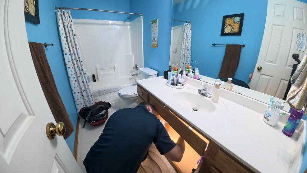 A local plumber from Thrasher Service fixes a clogged sink in Des Moines.